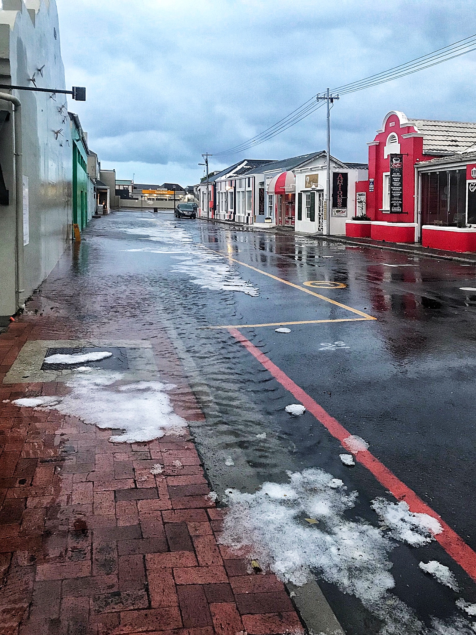 High Street, Hermanus flooded after the drains were overwhelmed by a heavy downpour with clumps of hail. Looking Southwest